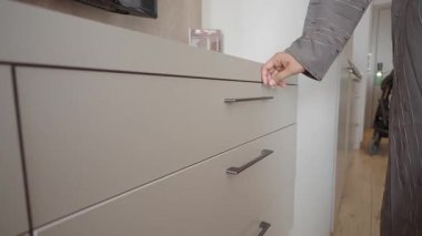 Gün içinde bir el, ev ortamında bir çekmeceyi açar..