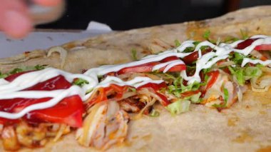 Aşçı yoğun bir yerde sebze, et ve sosla bir paket yapar..