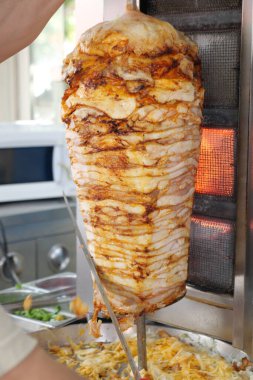 Aşçı, sokak yemekhanesinde dikey bir tükürükte et hazırlıyor..