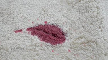 Kırmızı leke beyaz kumaştan temizleme yöntemi kullanılarak çıkarılır..