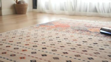 Ahşap zemine bir halı konur. Pencereden güneş ışığı süzülür..