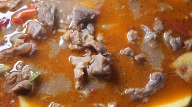 Sığır ve sebzeler sıcak bir yemek yapmak için tencerede kaynaşıyorlar..