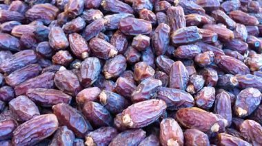 İnsanlar pazar ortamında büyük bir yığından tarih topluyor..