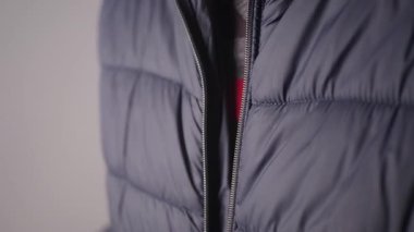 Fermuar kısmına odaklanan sıcak bir ceketin yakın görüntüsü..