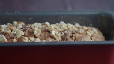 Bir insan mutfak ortamında fındıklı ekmek pişirir..