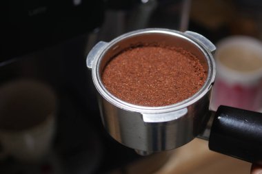 Kahve telveleri, espresso demlemeden önce metal bir portatif filtrede otururlar..