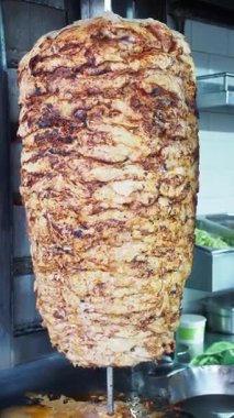 Bir sokak satıcısı kalabalık bir bölgedeki ızgaradan et dilimliyor..