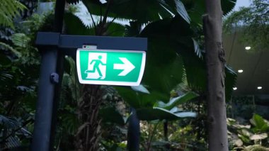 Bir çıkış işareti bitkilerle dolu yeşil bir alanı terk etmeyi gösteriyor..