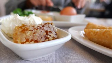 Bir kafede bal, peynir ve yumurta ile yayılmış kahvaltıdan zevk alıyorum..