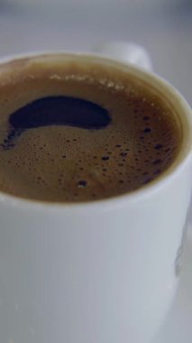 Yoğun bir kafede, beyaz bardakta sıcak Türk kahvesi.,