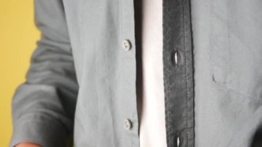 Bir kişi gömleğin düğmesini adım adım dikkatli iliklemeyi öğretir..