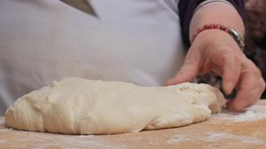 Bir insan basit malzemelerle ekmek yapmak için hamur hazırlar..