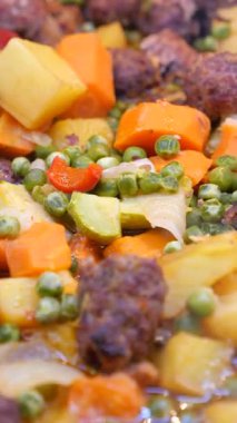 Yiyecek çeşitli sebzeler ve etle büyük bir tencerede pişiriliyor..