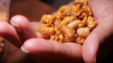 Bir panayırda gülümserken elinde patlamış mısır ve fındık karışımı tutuyor..