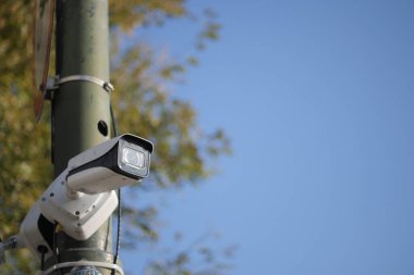 Açık mavi gökyüzünün altındaki direğe bir güvenlik kamerası yerleştirildi..