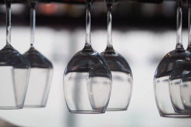 Bardaklar bir barda baş aşağı asılı duruyor. İçlerinde ışık parlıyor..