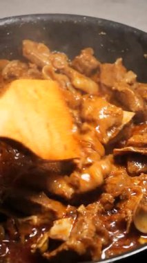 Biftek, lezzet katmak için baharat ve sos eklenmiş bir tavada pişiriliyor..