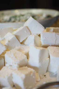 Peynir küpleri arka planda kase ile bir yüzeye yerleştirilir..
