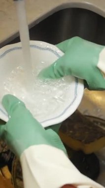 Eldivenli su kullanarak bulaşıkları lavaboda yıkarlar..