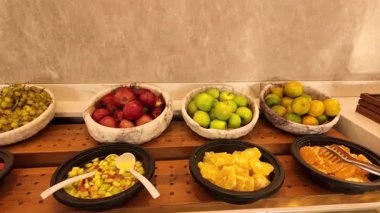 Misafirler kahvaltı sırasında masalarda çeşitli meyvelerin keyfini çıkarırlar..