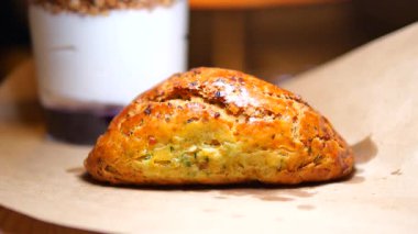 Kahverengi kağıt yüzeyde bitkilerle pişirilmiş bir çörek sergilenir..