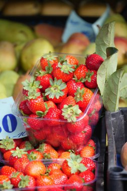 Çilekler bir market standında konteynırda sergilenir..