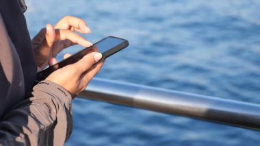 Suyun yanındayken bir insan akıllı telefondan yazar..