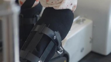 Klinikte rehabilitasyon cihazı kullanan küçük bir kız..