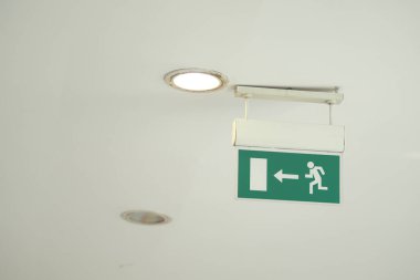 Kapıya doğru koşan bir figür ile çıkış yönünü gösterir.