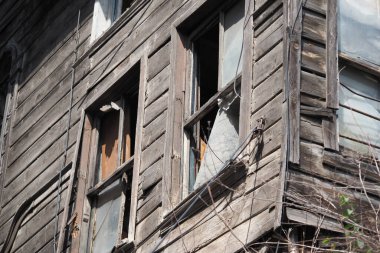 Yıpranmış ahşap bir yapının kırık camları ihmal ve yaşı gösteriyor..