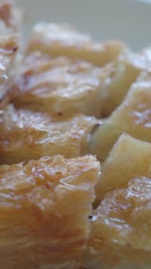 Aşçı, mutfak ortamında katmanlı ve şuruplu tatlı hamur işi hazırlar..