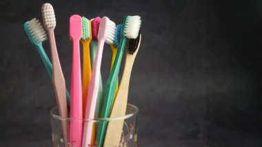 Farklı renkte çeşitli diş fırçaları bir bardağa konur..