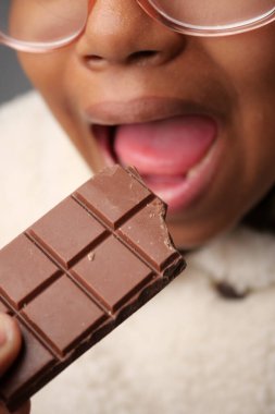 Çocuk heyecanla çikolatadan bir ısırık alıyor..