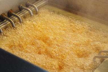 Sıcak yağ kızartma makinesinde fokurdarken, yemek içeride pişiyor..