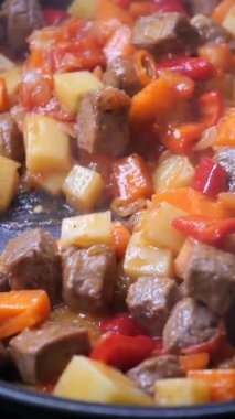 Sığır eti ve çeşitli sebzeler tavada birlikte pişiriliyor..