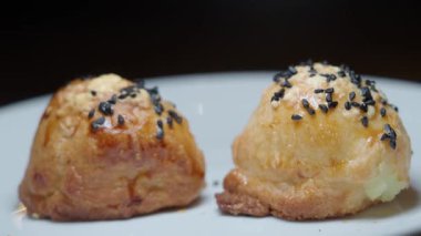 Üzerinde siyah tohumlar olan iki fırın beyaz bir tabağa konur..