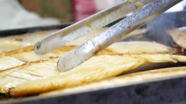 Sıcak hava koşullarında yerel bir pazarda balık pişirmek.