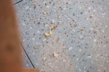 Yemek kırıntıları bir restoranın masasının altına yayılmış..