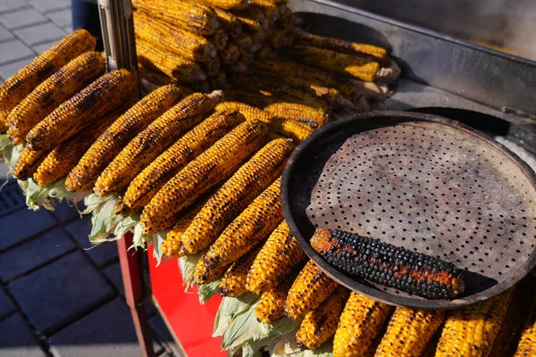 Koçanda mısır, gün ışığında bir markette ızgarada pişiyor..