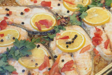 Balık filetosu limon dilimleri ve pişirmek için bitkilerle servis edilir..