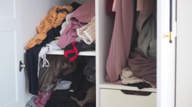 Daha iyi bir düzen için kıyafetleri dağınık bir dolapta sınıflandırmak ve düzenlemek..