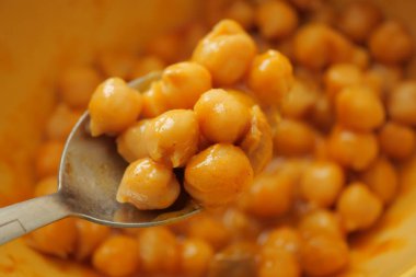 Nohut bir kaşıktan mutfaktaki bir kaseye servis ediliyor..