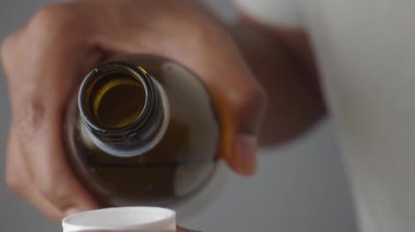 Sıvı ilaçları bir doz bardağına döküyorum..