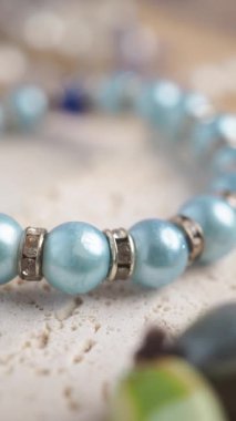 Yakın plan çekimde mavi ve gümüş boncuklar bir bilezik oluşturuyor..