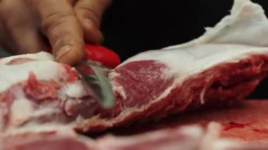 Bir insan günün erken saatlerinde açık pazarda et keser..