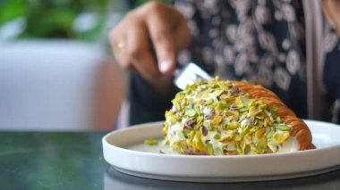 Bir kafede fıstıklı kruvasan yemek..