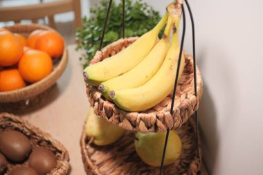 Sepetler taze muz ve portakalları ahşap bir masada tutar..