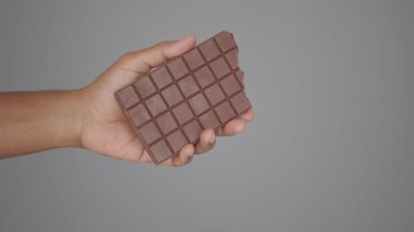 Bir insan elinde çikolatayla parçaları açıkça gösterir..