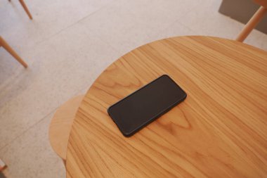 Ahşap masada akıllı telefon. Akıllı telefon kavramını kaybettim.