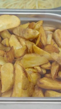 Taze pişmiş patates dilimleri metal bir tepside servis edilir..